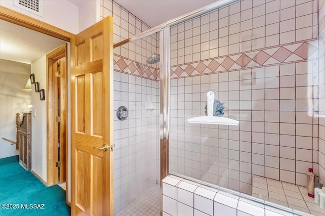 bathroom featuring a stall shower and visible vents