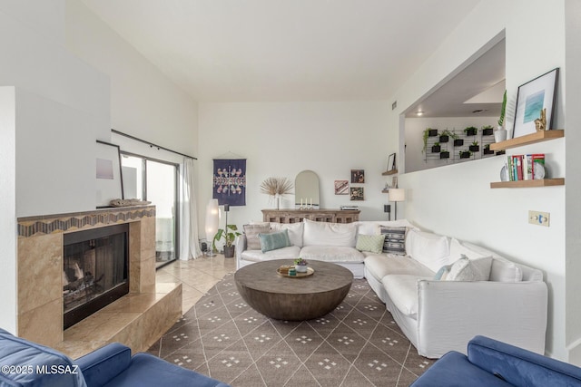 living room featuring tile patterned flooring and a fireplace with raised hearth