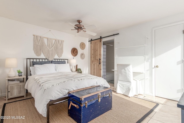 tiled bedroom with a barn door and a ceiling fan