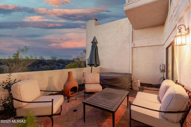 patio terrace at dusk featuring an outdoor living space