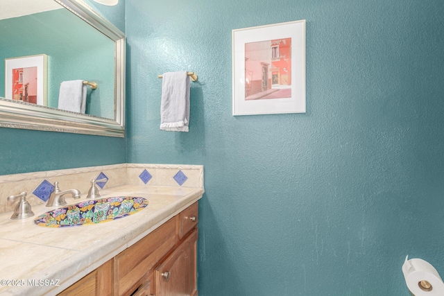 bathroom featuring a textured wall and vanity