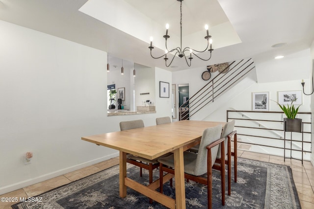 tiled dining space featuring baseboards, stairs, a tray ceiling, and a chandelier