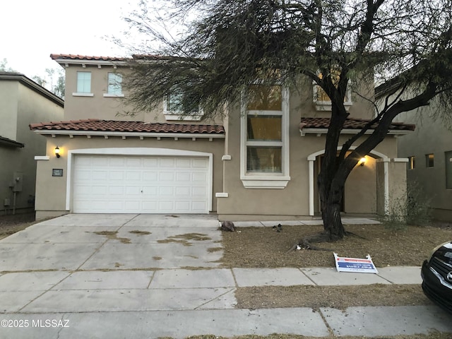 mediterranean / spanish-style house featuring a tile roof, driveway, an attached garage, and stucco siding