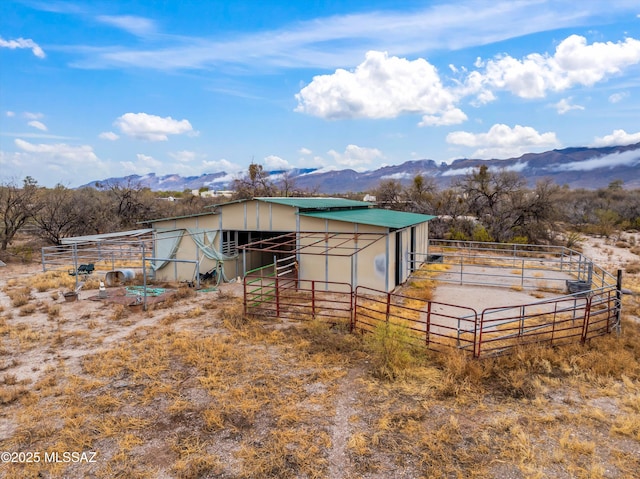 view of outbuilding featuring an outbuilding, an exterior structure, and a mountain view