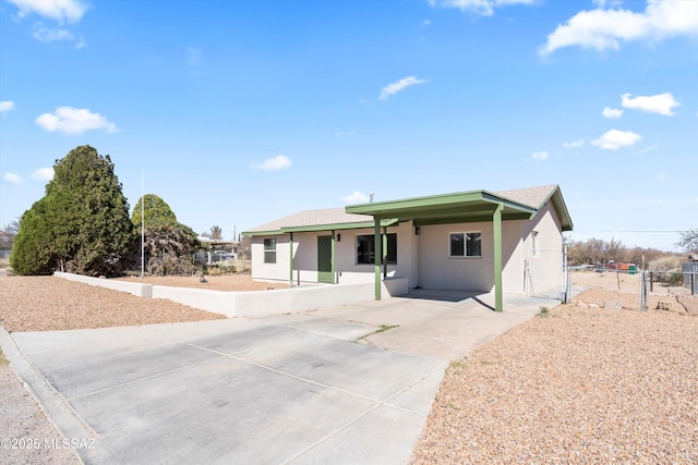 ranch-style house featuring a gate, fence, and stucco siding