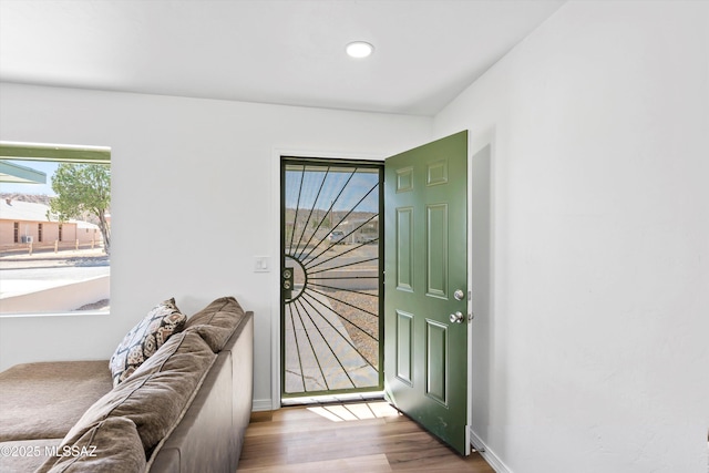 doorway to outside with plenty of natural light, baseboards, and wood finished floors