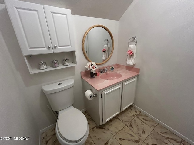 bathroom featuring vanity, toilet, and baseboards