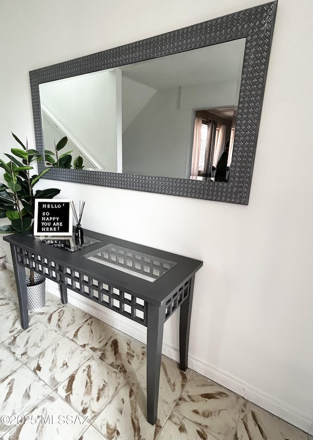interior space featuring baseboards and marble finish floor
