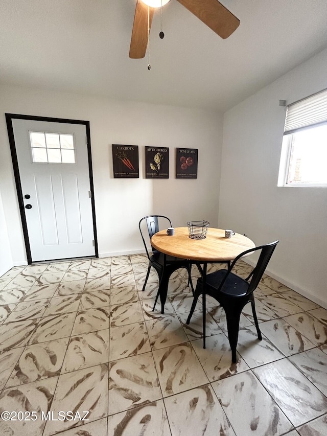 dining space with baseboards, marble finish floor, and ceiling fan