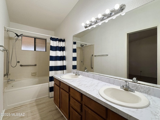 bathroom with shower / bath combination with curtain, wood finished floors, double vanity, and a sink