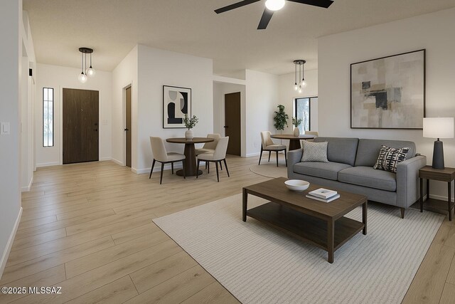 living room featuring baseboards, ceiling fan, light wood-style flooring, and plenty of natural light