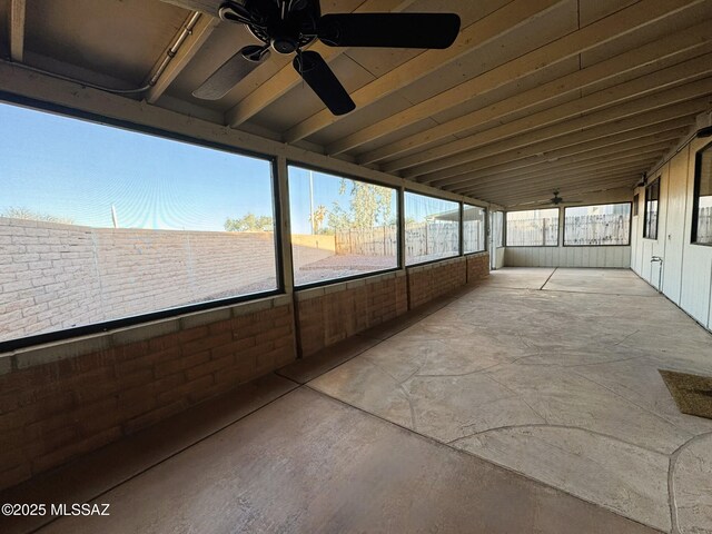 unfurnished sunroom featuring ceiling fan