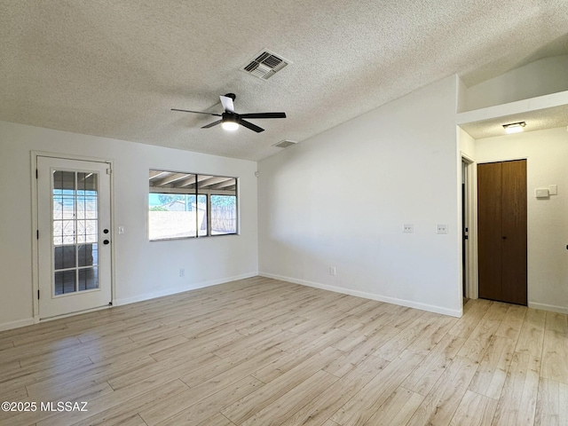 empty room with vaulted ceiling, light wood-style floors, visible vents, and ceiling fan