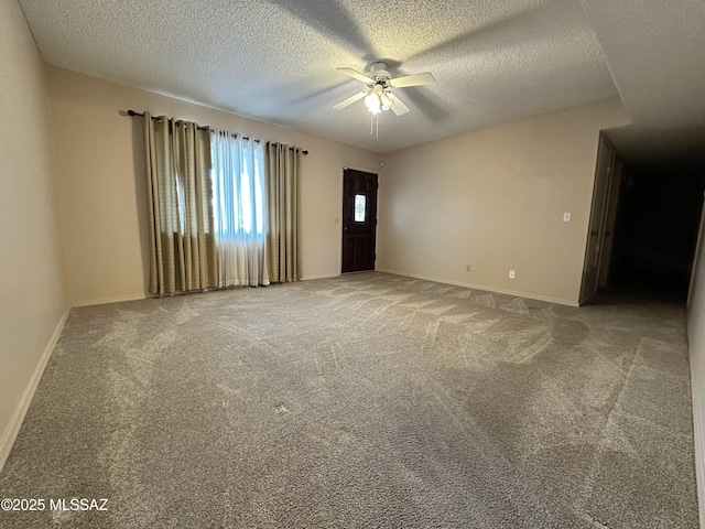 unfurnished room with carpet floors, a textured ceiling, baseboards, and a ceiling fan