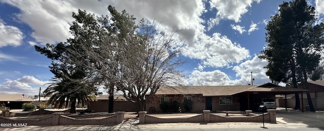 ranch-style house with concrete driveway, a carport, and brick siding