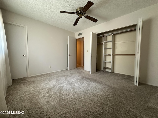 unfurnished bedroom with carpet floors, visible vents, ceiling fan, and a textured ceiling