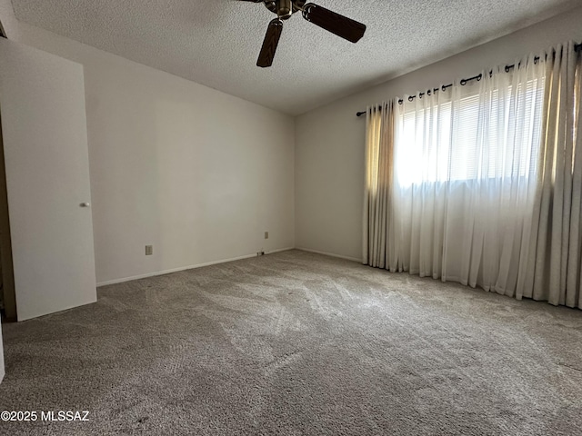 carpeted spare room featuring ceiling fan and a textured ceiling