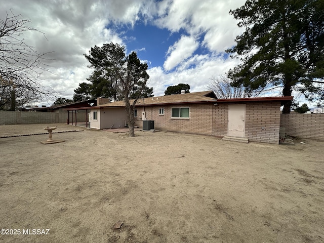 back of house featuring brick siding, fence, a patio, and central air condition unit