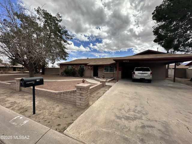 single story home featuring driveway, a carport, and brick siding