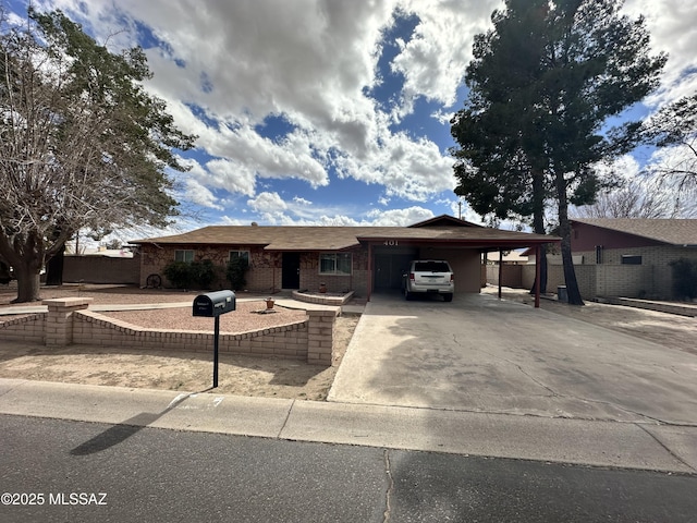 ranch-style home with a carport, brick siding, and driveway