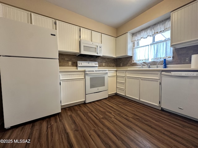 kitchen featuring dark wood-type flooring, white appliances, light countertops, and tasteful backsplash