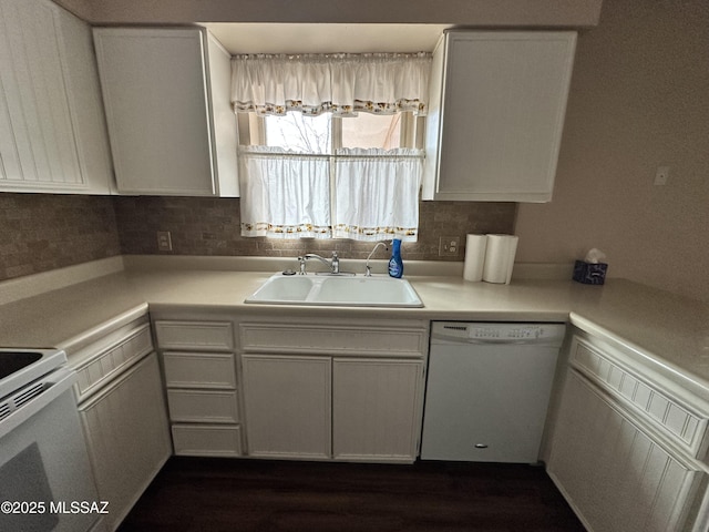 kitchen featuring dishwasher, light countertops, a sink, and white cabinetry