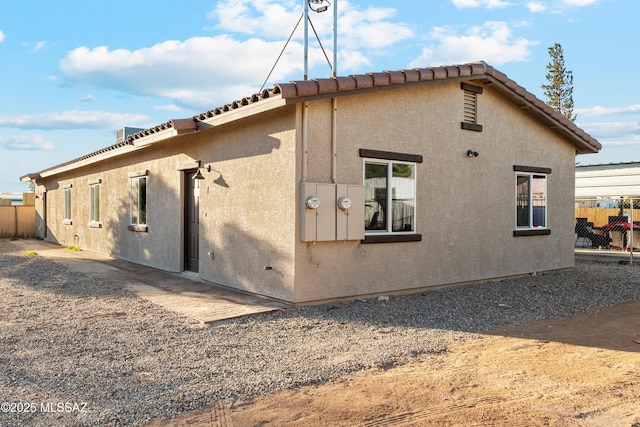 view of property exterior featuring fence and stucco siding