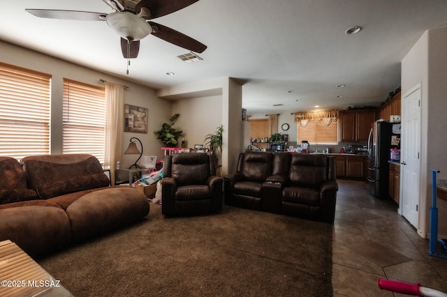 living area with dark tile patterned flooring, recessed lighting, visible vents, and a ceiling fan