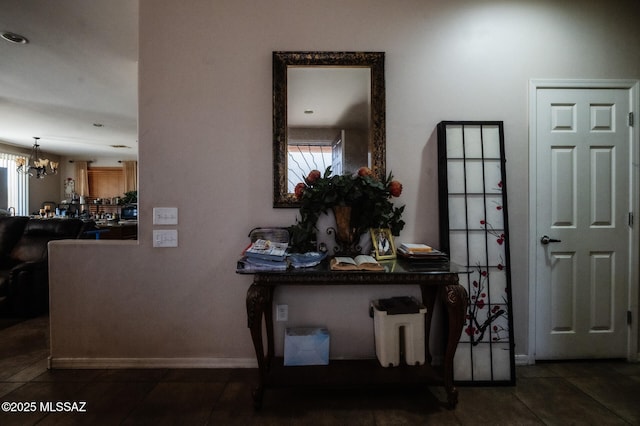 corridor with a chandelier and baseboards