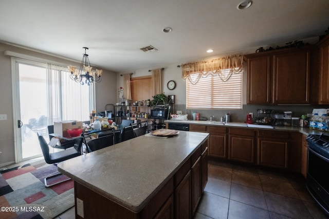 kitchen featuring recessed lighting, visible vents, a center island, black appliances, and an inviting chandelier