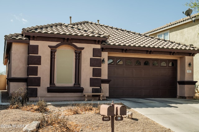 mediterranean / spanish home with a garage, concrete driveway, a tile roof, and stucco siding