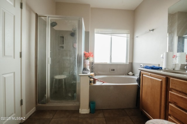 full bathroom with a stall shower, a garden tub, vanity, and tile patterned floors
