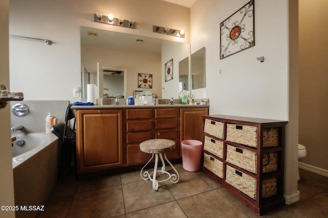 bathroom with a garden tub, tile patterned flooring, toilet, a sink, and double vanity
