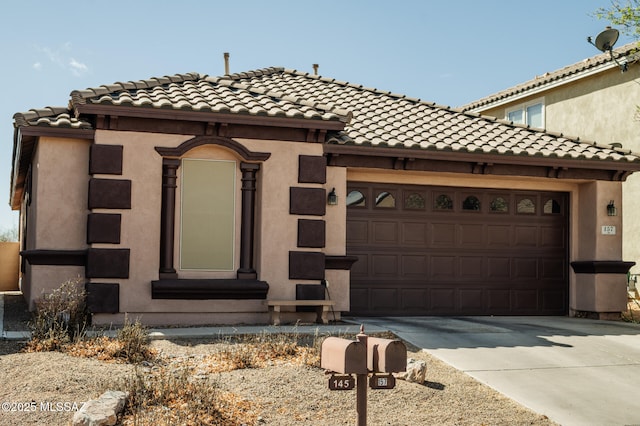 mediterranean / spanish house featuring concrete driveway, an attached garage, a tile roof, and stucco siding