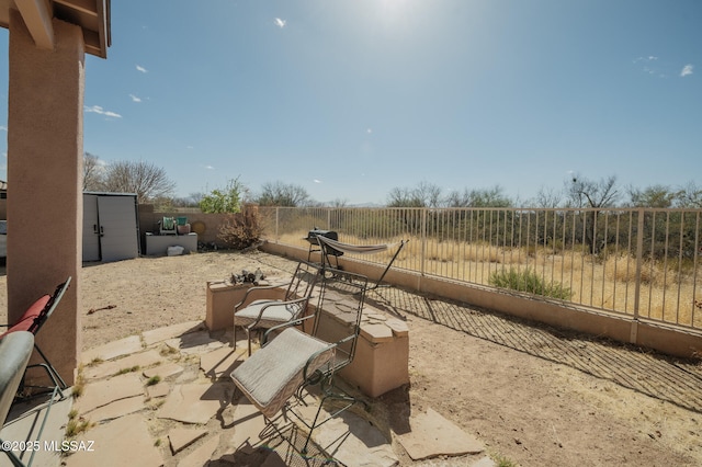 view of patio with a fenced backyard and an outdoor structure