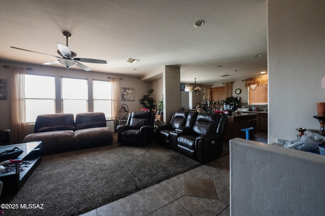 tiled living room featuring visible vents and ceiling fan with notable chandelier