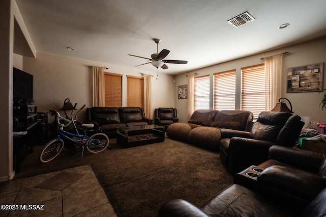 tiled living area with ceiling fan and visible vents