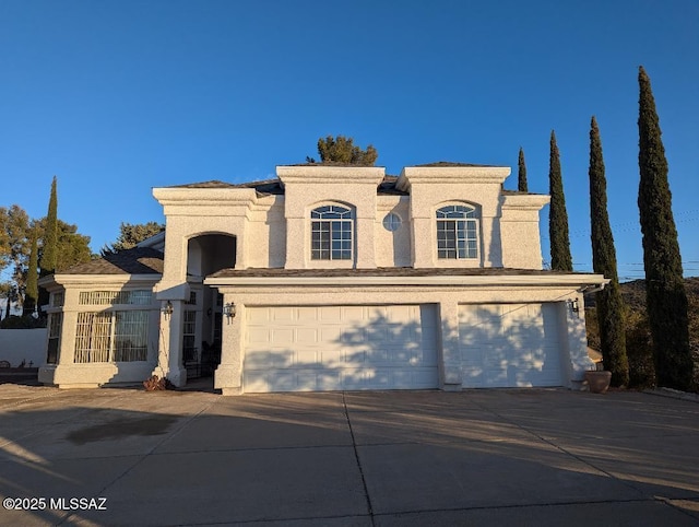 mediterranean / spanish home featuring stucco siding, concrete driveway, and a garage