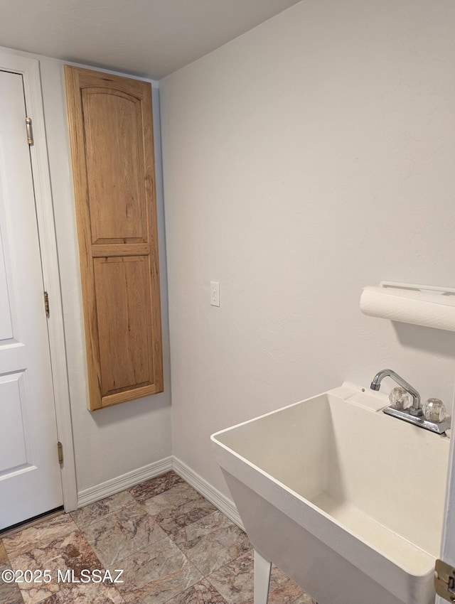 bathroom featuring baseboards and a sink