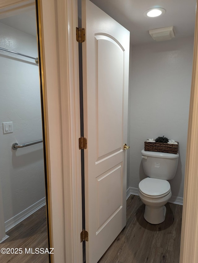 bathroom featuring visible vents, toilet, baseboards, and wood finished floors