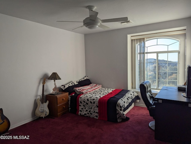 carpeted bedroom featuring a ceiling fan, visible vents, and baseboards