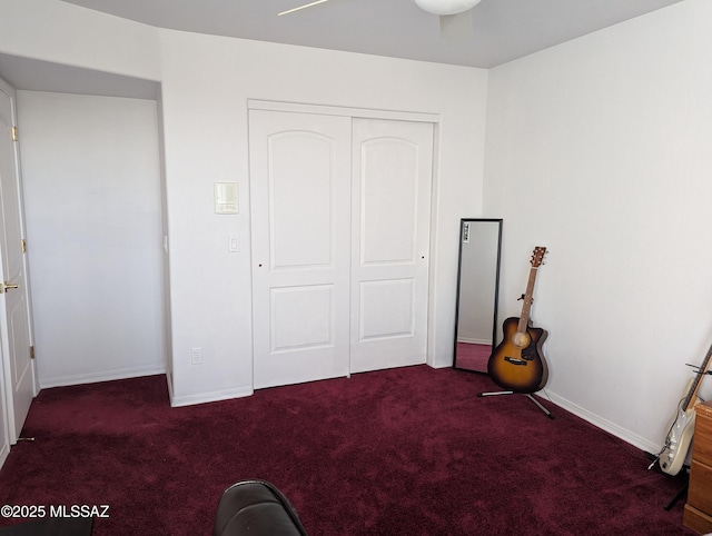 unfurnished bedroom with a closet, baseboards, and dark colored carpet