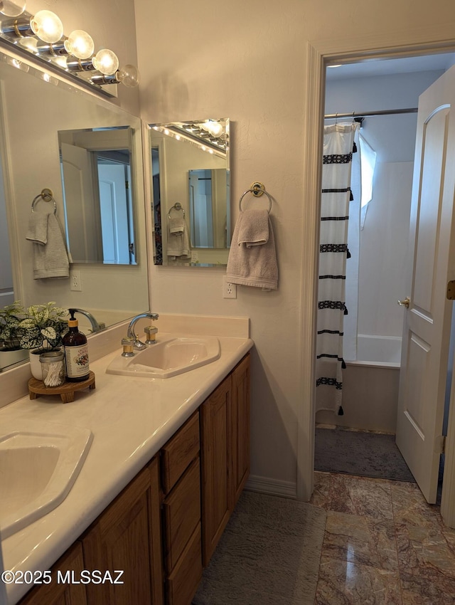 bathroom with double vanity, shower / tub combo, baseboards, and a sink