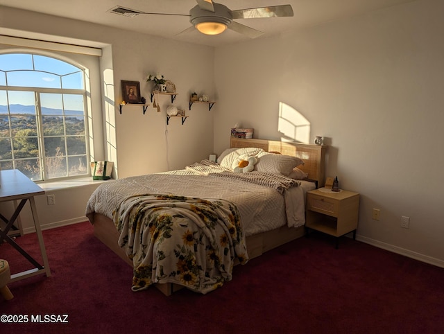 carpeted bedroom with visible vents, a mountain view, a ceiling fan, and baseboards