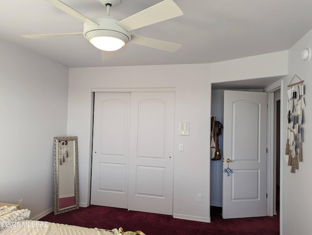 unfurnished bedroom with a closet, dark carpet, a ceiling fan, and baseboards