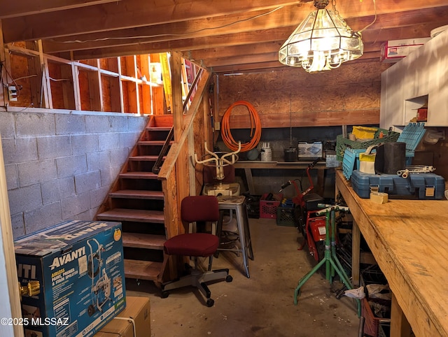 unfinished basement with concrete block wall and stairs