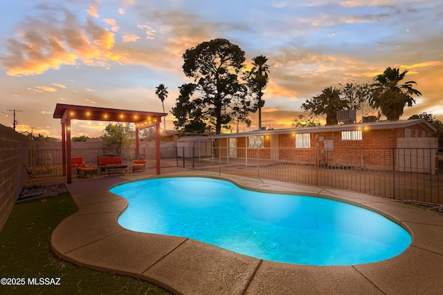 pool at dusk featuring a patio area, a fenced backyard, and a fenced in pool