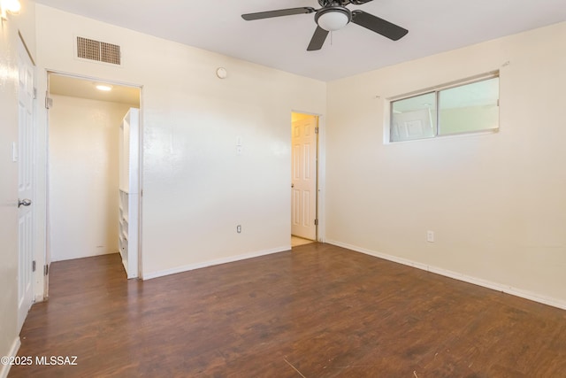 empty room with a ceiling fan, baseboards, visible vents, and wood finished floors