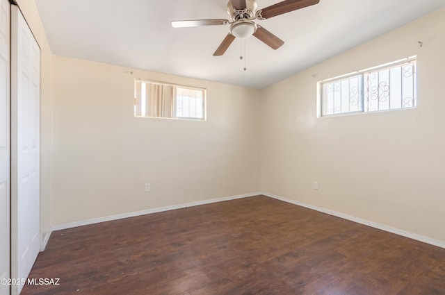 empty room with plenty of natural light, wood finished floors, and baseboards