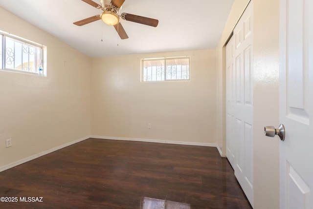 empty room with a ceiling fan, baseboards, and wood finished floors